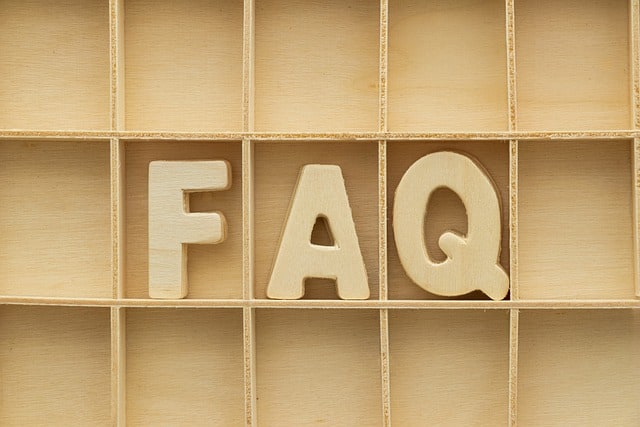 Eine Holzkiste mit dem Wort „FAQ“ darauf, perfekt zum Organisieren von Website-FAQs und zum Verbessern des Google-Rankings.